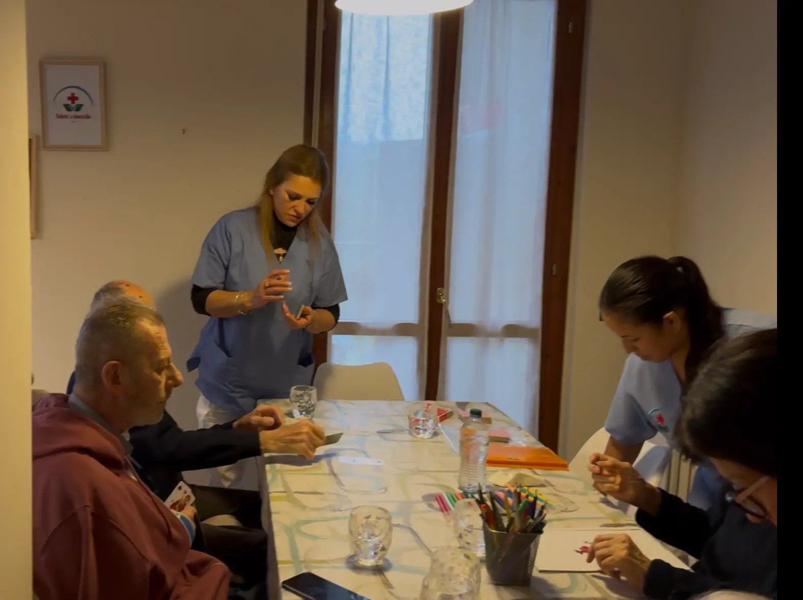 Attività di gruppo — ospiti e operatori al tavolo della sala pranzo